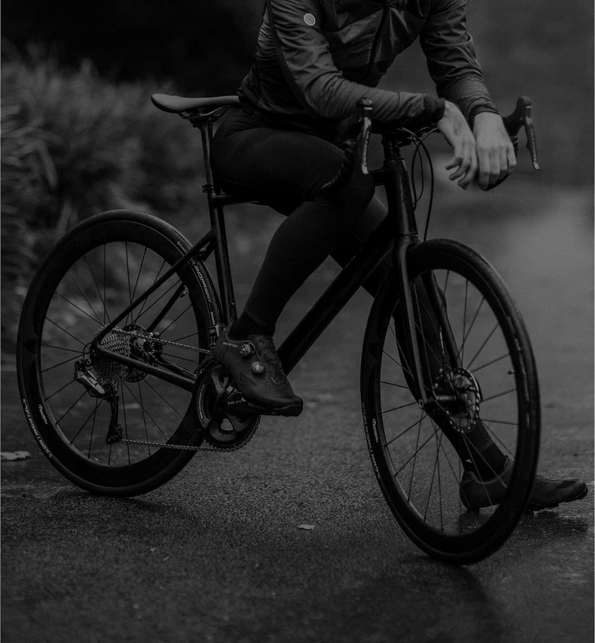 Pessoa parada em cima de uma bicicleta.